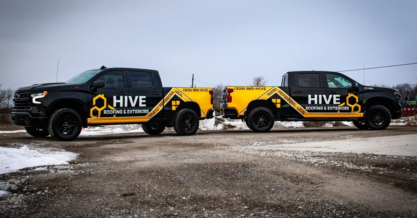 Two matching branded fleet trucks parked side by side, wrapped by Aftershock